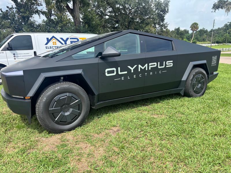 Matte black Tesla Cybertruck with an electrical company logo on the doors