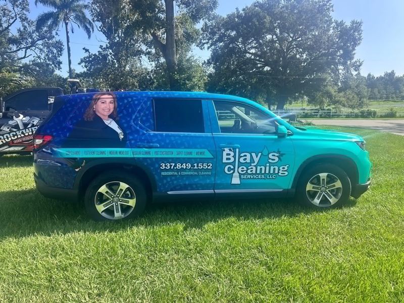 Minivan with teal printed graphics for a cleaning company