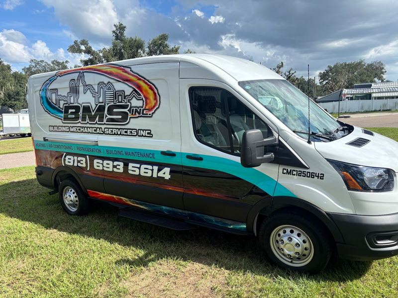 White Ford Transit van with teal and orange mechanical services graphics